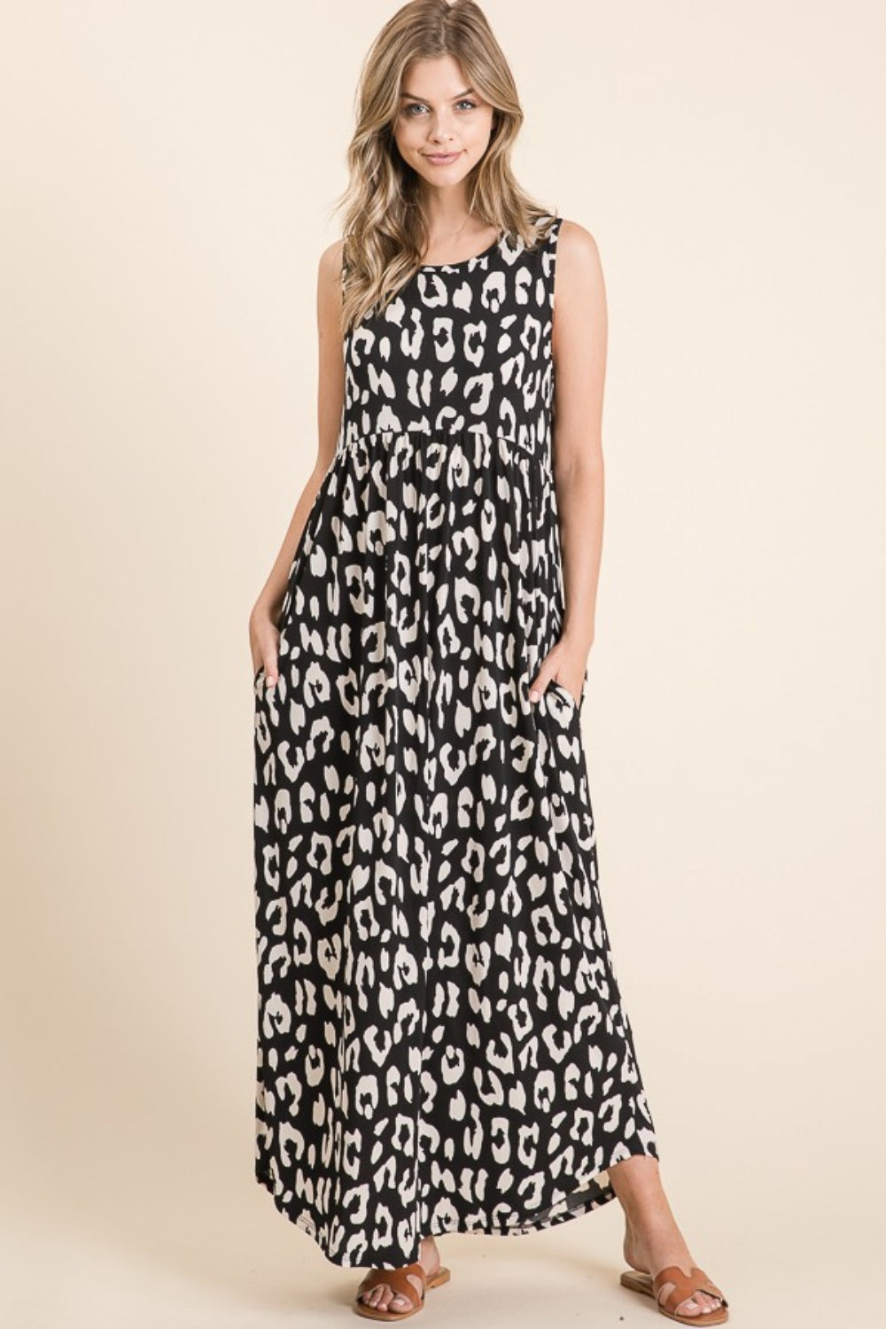 A person wearing the BOMBOM Leopard Maxi Dress with Pockets, paired with brown sandals, is standing against a beige background.