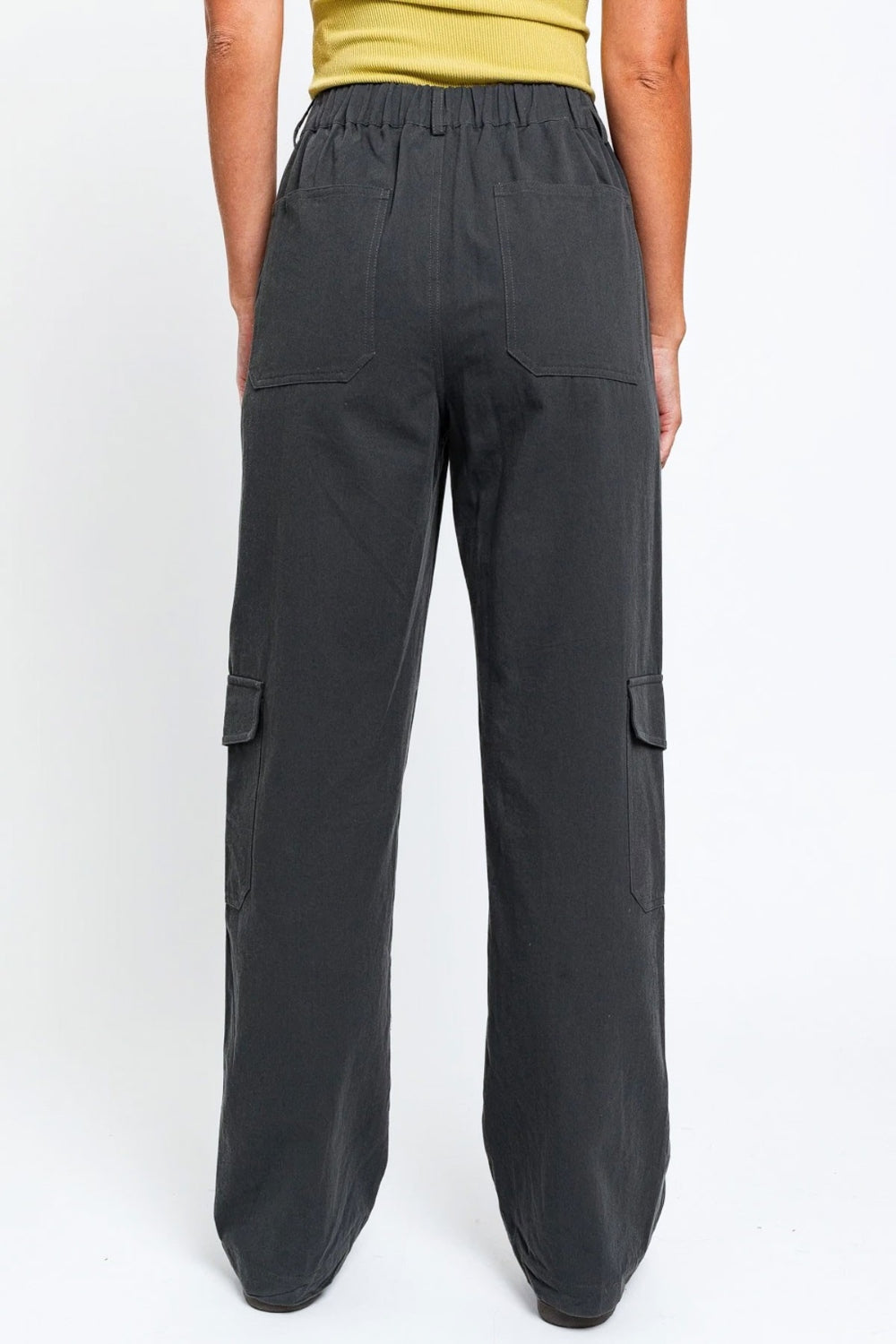   Person wearing the Le Lis High Waisted Wide Leg Cargo Pants with Pockets, featuring side pockets and zipper details, standing against a plain white background.