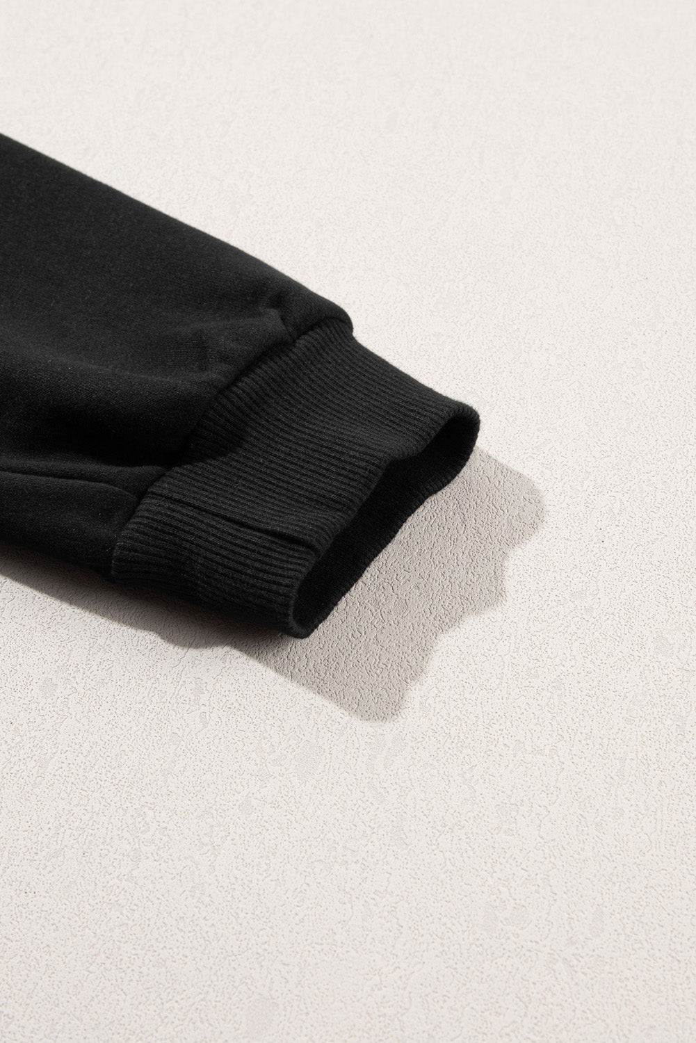 A person is standing with their back to the camera, wearing a Black Snap Buttons Side Splits Pullover Sweatshirt and white pants.