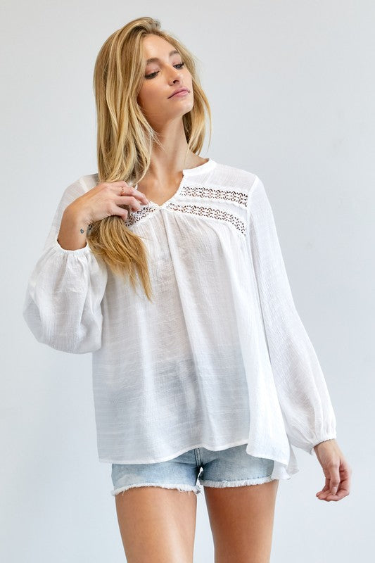 A person wearing a Solid V-Neck Blouse Top and denim shorts stands against a plain background.