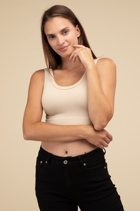 A person with long brown hair wearing the Ribbed Seamless Crop Top in light blue and black pants stands against a beige background, showcasing a perfect summer essential.