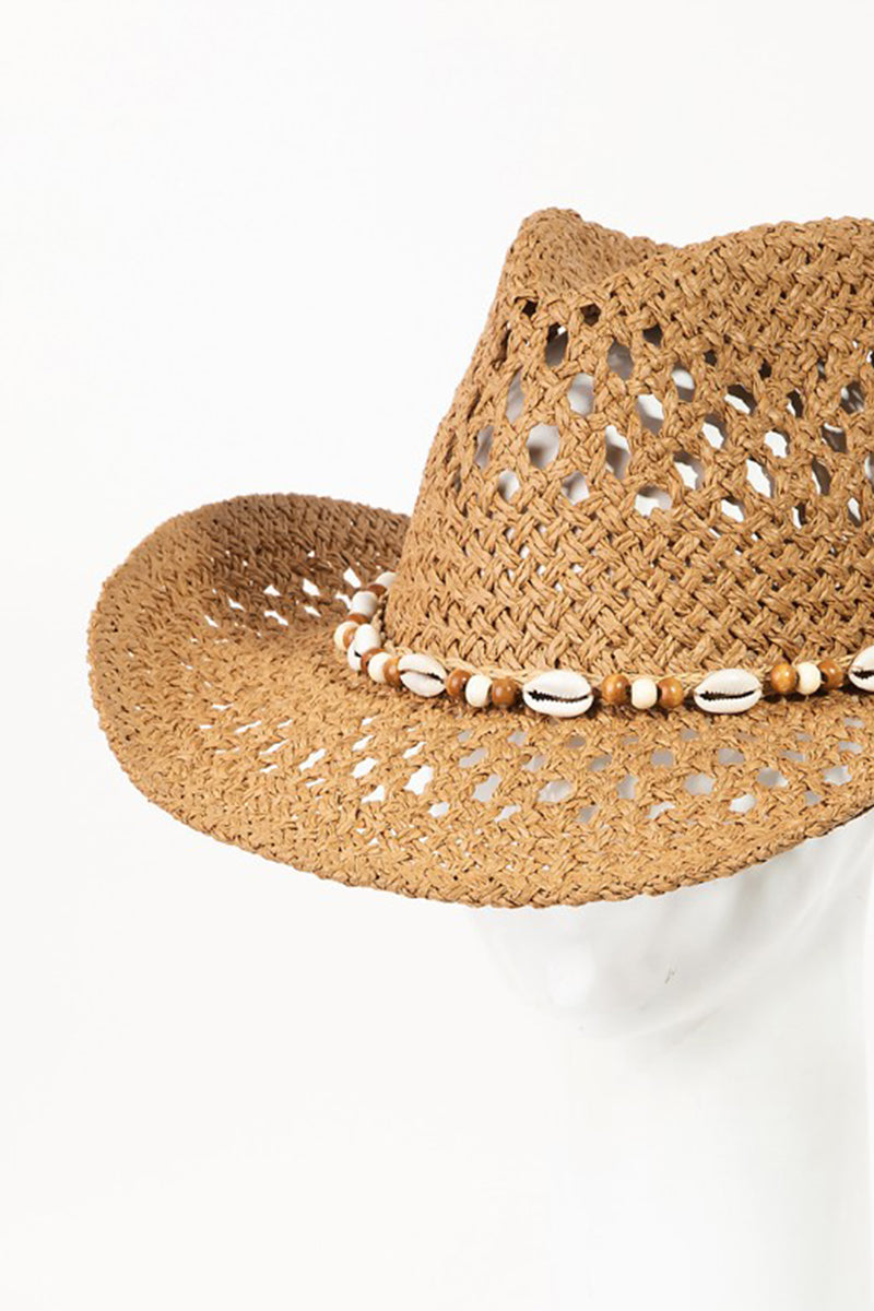 The Fame Cowrie Shell Beaded String Straw Hat, featuring cowrie shells and decorative beads, sits elegantly on a white mannequin head.