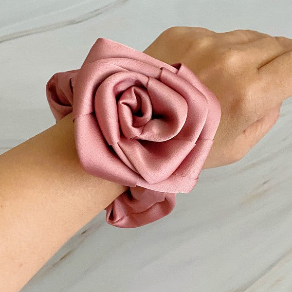 Four high-quality Art Of Work Satin Rose Scrunchies in black, pink, green, and cream arranged on a marble surface.