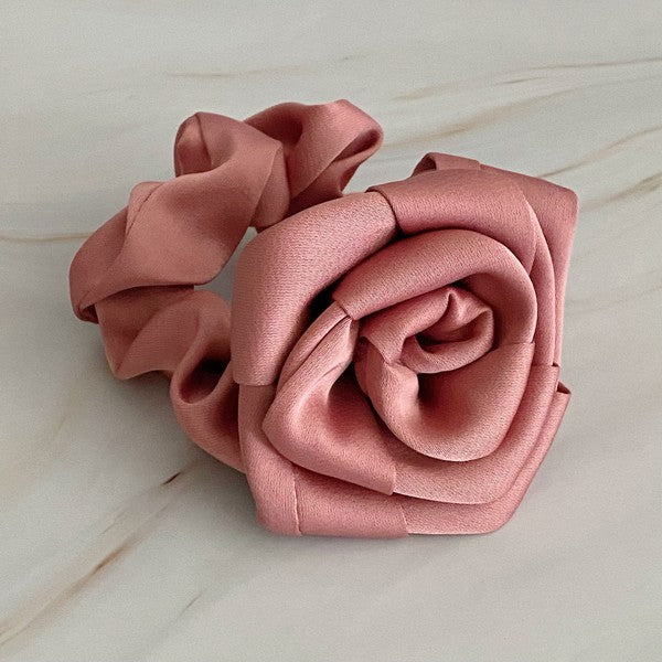 Four high-quality Art Of Work Satin Rose Scrunchies in black, pink, green, and cream arranged on a marble surface.