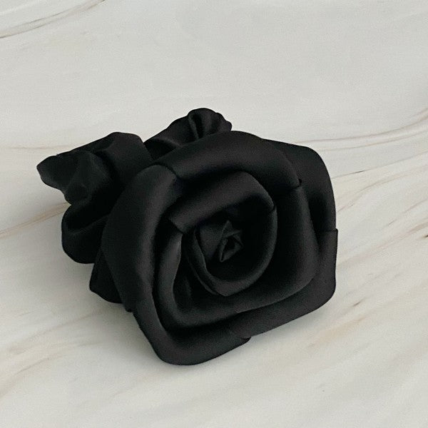 Four high-quality Art Of Work Satin Rose Scrunchies in black, pink, green, and cream arranged on a marble surface.