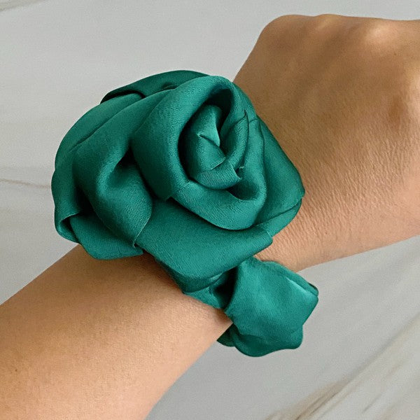 Four high-quality Art Of Work Satin Rose Scrunchies in black, pink, green, and cream arranged on a marble surface.
