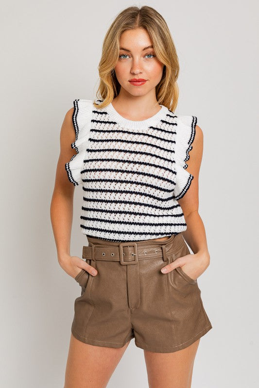 A woman is wearing a Round Neck Ruffle Sleeve Stripe Knit Top in a chic print, sleeveless white and brown stripe design, paired with light blue denim shorts, standing against a plain background.