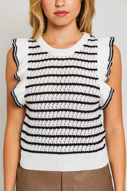 A woman is wearing a Round Neck Ruffle Sleeve Stripe Knit Top in a chic print, sleeveless white and brown stripe design, paired with light blue denim shorts, standing against a plain background.