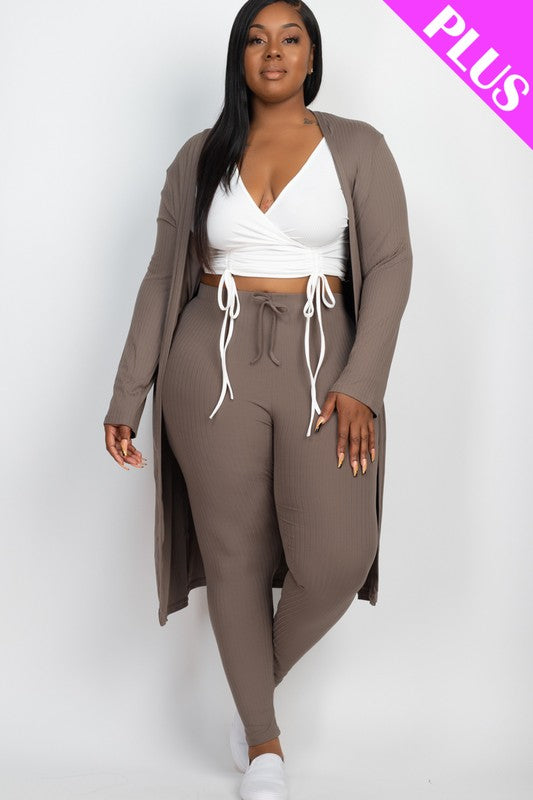 A woman wears a Plus Size Ribbed Long Cardigan & Leggings Set in beige with a white wrap top. The image features a "PLUS" label in the upper right corner.