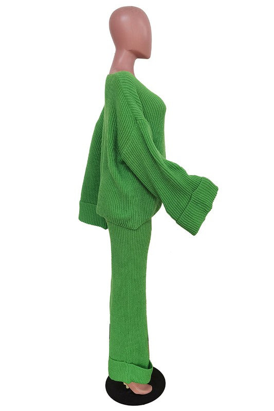 Person posing in the WOMEN FASHION 2PCS SWEATER PANTS SET, featuring a loose-fitting green knit top with bell sleeves and matching wide-leg pants.