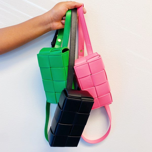 Three small Candy Cube Woven Sling Bags in green, pink, and black, made from faux leather PU material, being held by a hand against a white background.