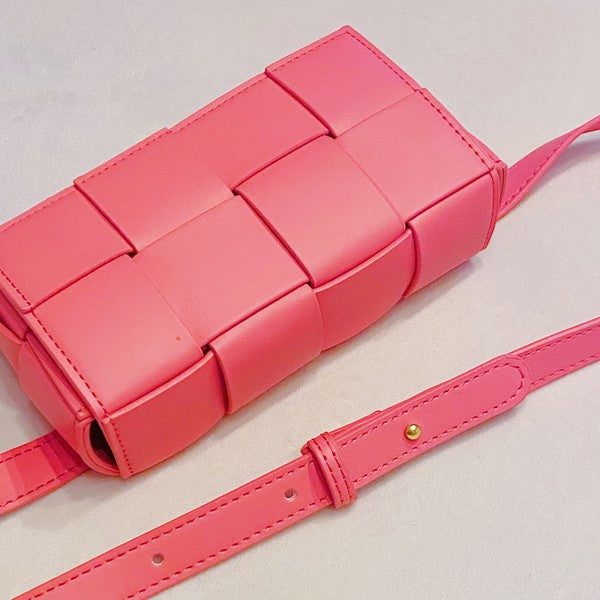 Three small Candy Cube Woven Sling Bags in green, pink, and black, made from faux leather PU material, being held by a hand against a white background.