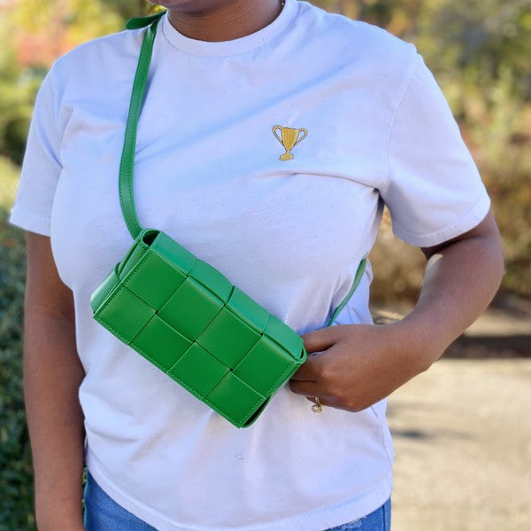 Three small Candy Cube Woven Sling Bags in green, pink, and black, made from faux leather PU material, being held by a hand against a white background.