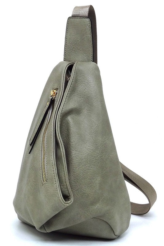 The Fashion Sling Bag Backpack, made of green faux vegan leather, showcases a single adjustable shoulder strap and two zippered compartments, displayed against a white background.