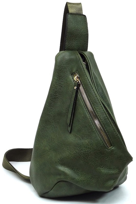 The Fashion Sling Bag Backpack, made of green faux vegan leather, showcases a single adjustable shoulder strap and two zippered compartments, displayed against a white background.