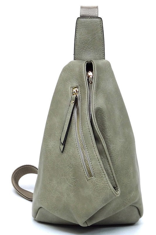 The Fashion Sling Bag Backpack, made of green faux vegan leather, showcases a single adjustable shoulder strap and two zippered compartments, displayed against a white background.