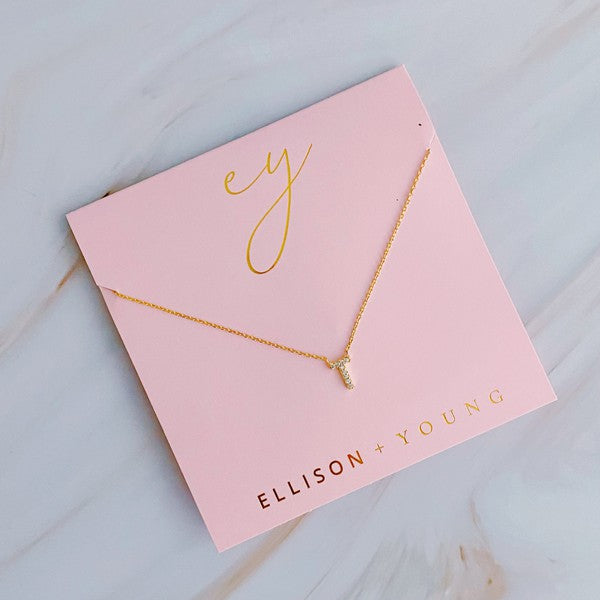 Assorted 18k gold plated Understated Beauty Initial Necklaces with various pendants, including initial necklaces and cubic zirconia embellishments, displayed in parallel lines on a light surface.