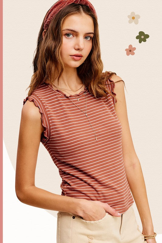 A woman stands against a neutral background with floral designs, wearing the Brushed Stripe Ruffle Sleeve Top and a headband.