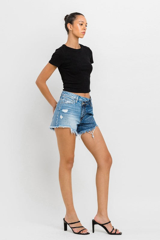 A person wearing Super High Rise Two Tone Denim Shorts and black high-heeled sandals stands against a plain background.