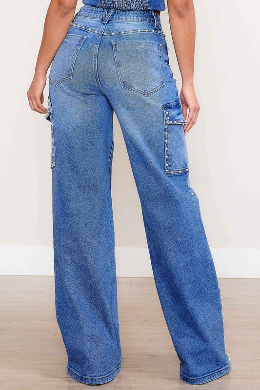 A person stands against a plain backdrop, dressed in a denim crop top and the Pearl High-Rise Wide Leg Cargo Jeans. Their hands rest casually by their sides, highlighting the effortless style of this denim collection.