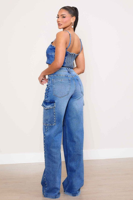 A person stands against a plain backdrop, dressed in a denim crop top and the Pearl High-Rise Wide Leg Cargo Jeans. Their hands rest casually by their sides, highlighting the effortless style of this denim collection.