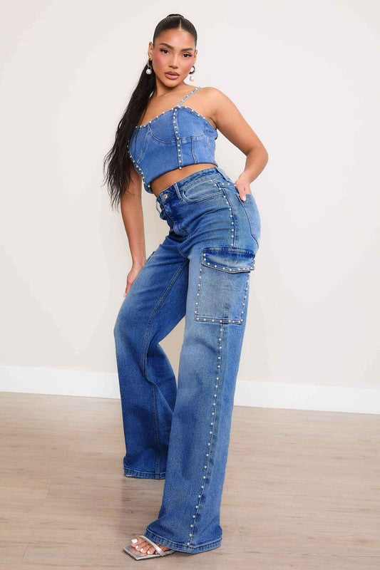 A person stands against a plain backdrop, dressed in a denim crop top and the Pearl High-Rise Wide Leg Cargo Jeans. Their hands rest casually by their sides, highlighting the effortless style of this denim collection.