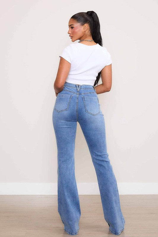 A person wearing Square Pocket Bootcut Jeans crafted from premium denim material, paired with a cropped white top.