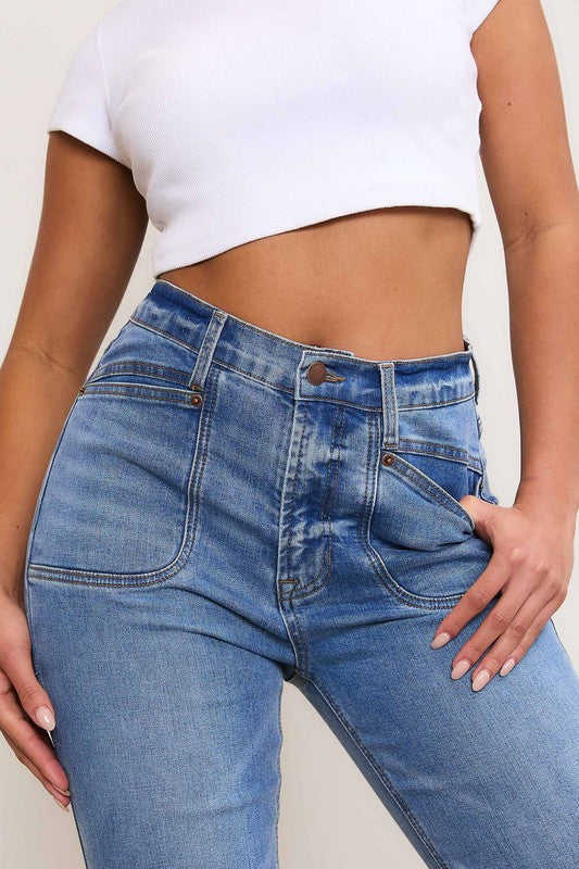 A person wearing Square Pocket Bootcut Jeans crafted from premium denim material, paired with a cropped white top.