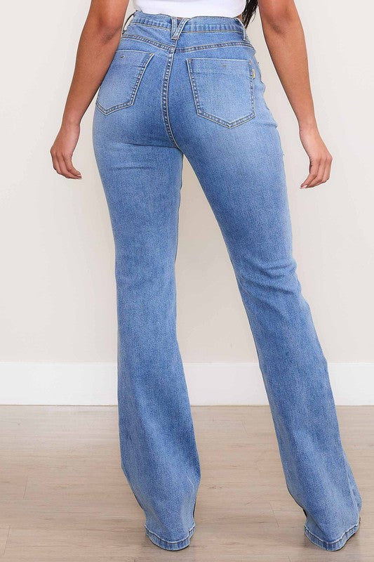 A person wearing Square Pocket Bootcut Jeans crafted from premium denim material, paired with a cropped white top.