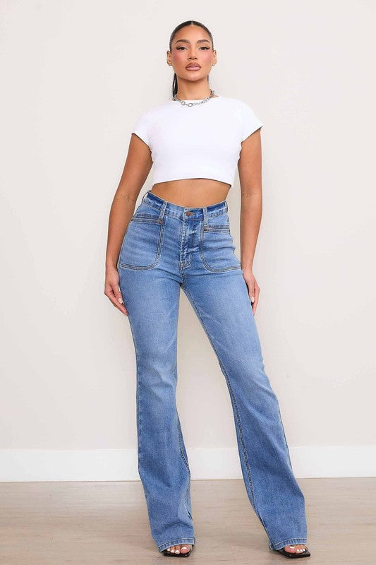 A person wearing Square Pocket Bootcut Jeans crafted from premium denim material, paired with a cropped white top.