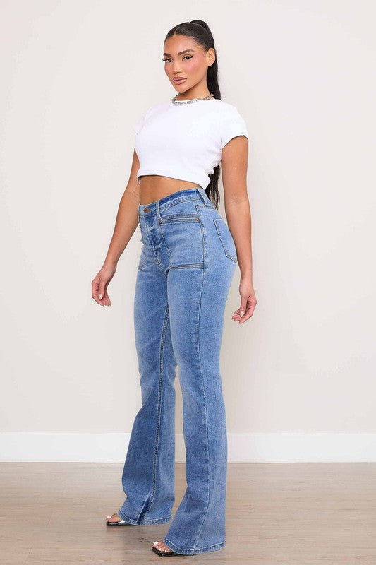 A person wearing Square Pocket Bootcut Jeans crafted from premium denim material, paired with a cropped white top.