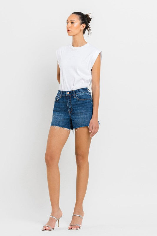 A person wearing High Rise Slit Raw Hem A-Line Shorts and silver sandals stands against a white background.