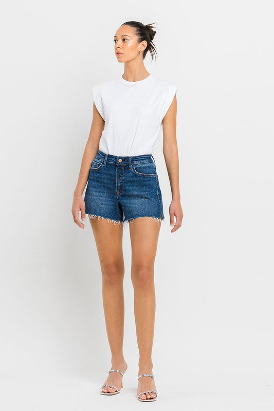 A person wearing High Rise Slit Raw Hem A-Line Shorts and silver sandals stands against a white background.