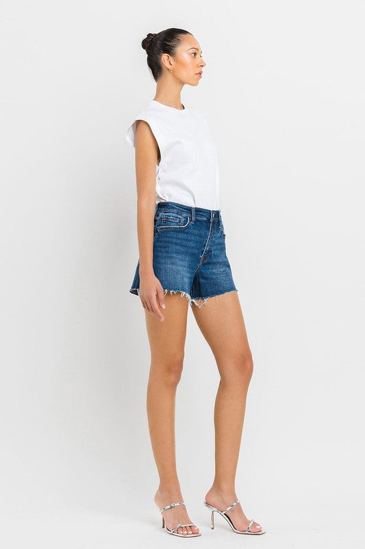 A person wearing High Rise Slit Raw Hem A-Line Shorts and silver sandals stands against a white background.