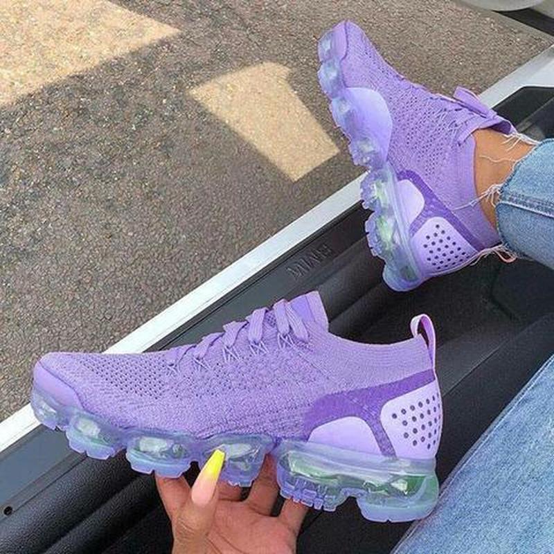 Purple sneakers women casual shoes mesh air-cushion flat on a person's feet, showcasing the sleek design and exceptional comfort from heel to toe.