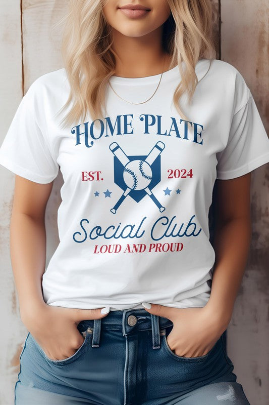 Person wearing a white "Home Plate, Social Club, Baseball Graphic Tee" featuring crossed bats and a baseball graphic, along with "EST. 2024" and "LOUD AND PROUD" text, paired with blue jeans.