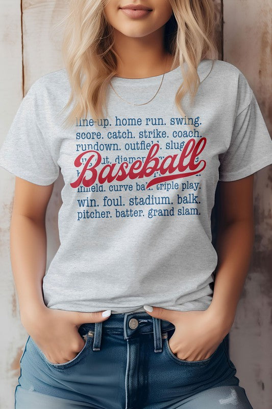 A person wearing the "Line Up, Home Run, Baseball Graphic Tee," which features baseball-related terms like "line-up," "home run," "coach," and "grand slam." The word "Baseball" is prominently displayed in red script. This t-shirt, perfect for sports enthusiasts, is made of eco-friendly materials.