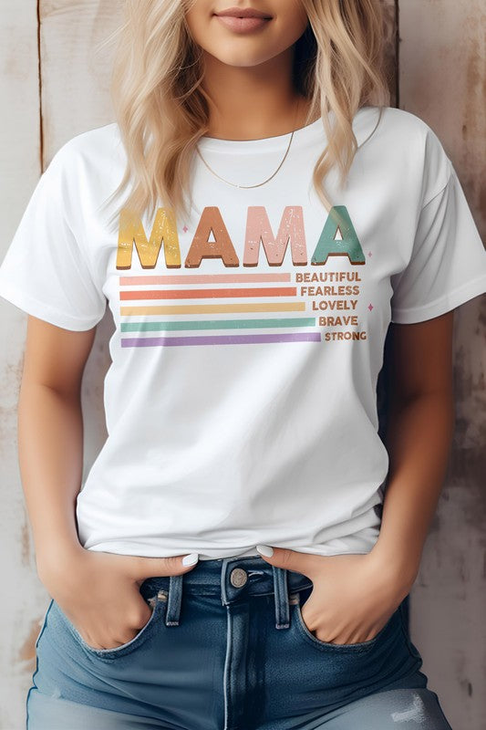 A person wearing the MAMA Graphic Tee, a beige shirt featuring the word "MAMA" in colorful letters and descriptions like "Beautiful," "Fearless," "Lovely," "Brave," and "Strong" written below—perfect for Mother's Day.