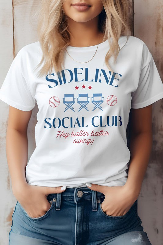 A person is wearing the Sideline Social Club Baseball Graphic Tee, displaying the words "Hey batter batter swing!" alongside images of two baseballs and three director's chairs. This white T-shirt features a unisex fit, making it an ideal choice for any baseball fan.