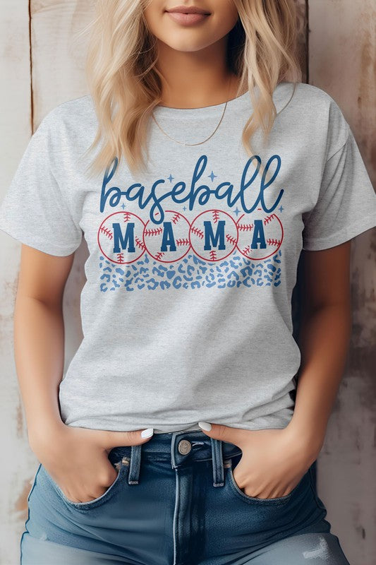 A woman wearing a Baseball Mama Graphic Tee featuring a baseball and leopard print design in light grey, standing with her hands in the pockets of her jeans, epitomizing the baseball life.