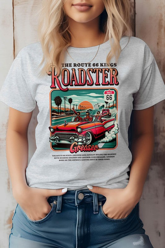 A person wearing the "Roadster Royalty, Retro Vintage Graphic Tee," which features vintage-style artwork promoting Route 66 with a red roadster and text reading "Roadster" and "Greaser." The unisex fit T-shirt is made from eco-friendly materials. The person has their hands in their jean pockets.