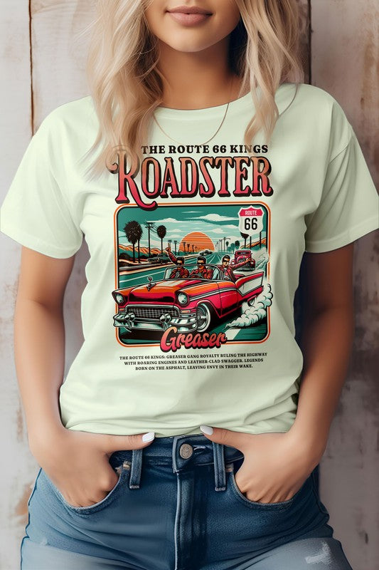 A person wearing the "Roadster Royalty, Retro Vintage Graphic Tee," which features vintage-style artwork promoting Route 66 with a red roadster and text reading "Roadster" and "Greaser." The unisex fit T-shirt is made from eco-friendly materials. The person has their hands in their jean pockets.