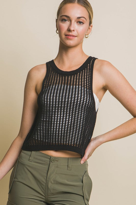 A person poses in a beige Sleeveless Open Knit Crop Top paired with tan drawstring pants against a light background.