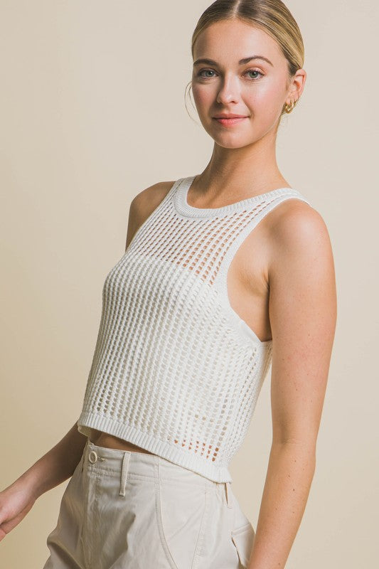 A person poses in a beige Sleeveless Open Knit Crop Top paired with tan drawstring pants against a light background.