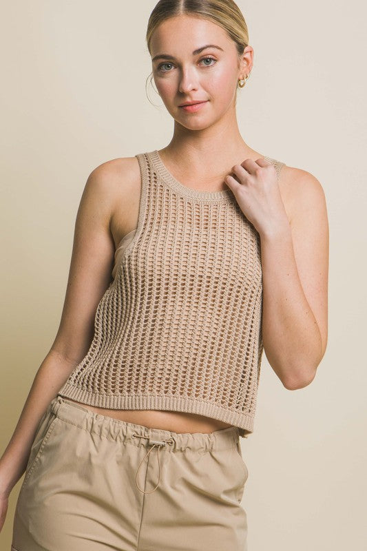 A person poses in a beige Sleeveless Open Knit Crop Top paired with tan drawstring pants against a light background.