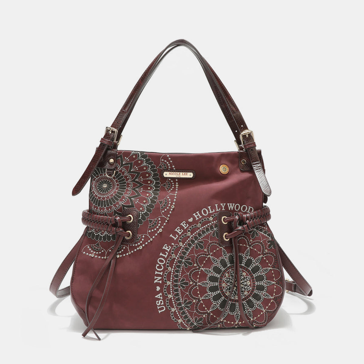 The Nicole Lee USA Side Braided Tassel Inlaid Rhinestone Embroidery Hobo Bag features intricately designed white mandala patterns on brown vegan leather, along with "Nicole Lee Hollywood USA" text. It includes top handles and decorative braided accents, as well as adjustable dual shoulder straps for added versatility.