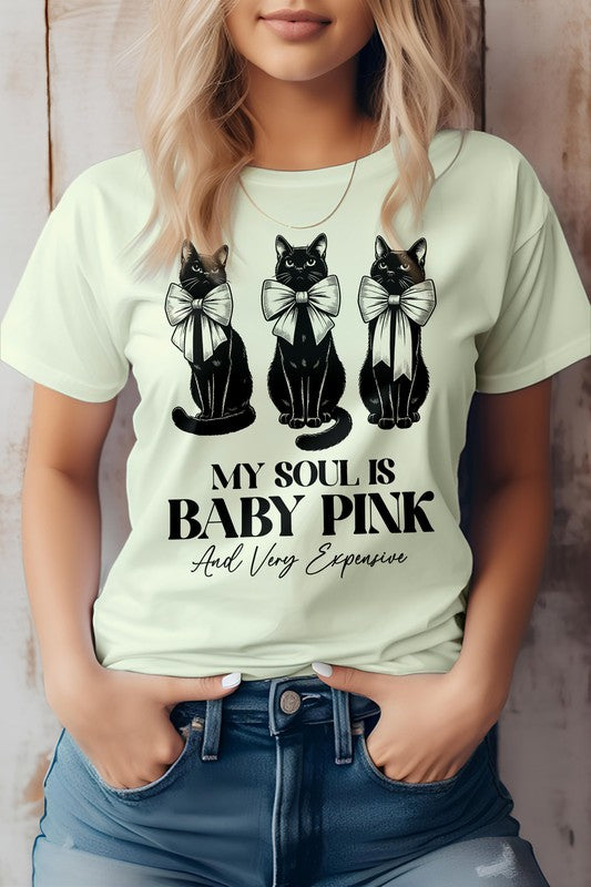 A person wearing a light pink Vintage Coquette Cat Graphic Tee featuring three pink cats with bows and the text, "MY SOUL IS BABY PINK And Very Expensive.