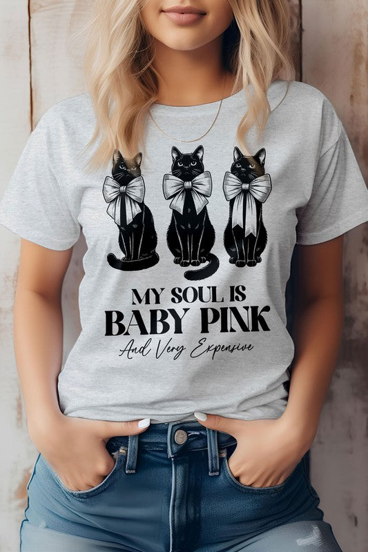 A person wearing a light pink Vintage Coquette Cat Graphic Tee featuring three pink cats with bows and the text, "MY SOUL IS BABY PINK And Very Expensive.