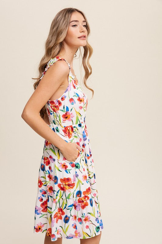 A woman can be seen twirling in the Flower Print Square Neck Dress, which features ruffle shoulder straps, while maintaining a neutral expression against a plain background.