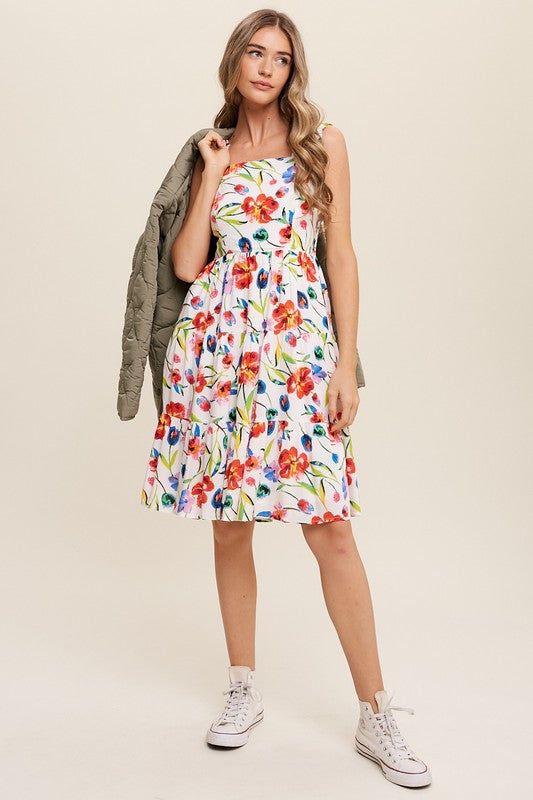 A woman can be seen twirling in the Flower Print Square Neck Dress, which features ruffle shoulder straps, while maintaining a neutral expression against a plain background.